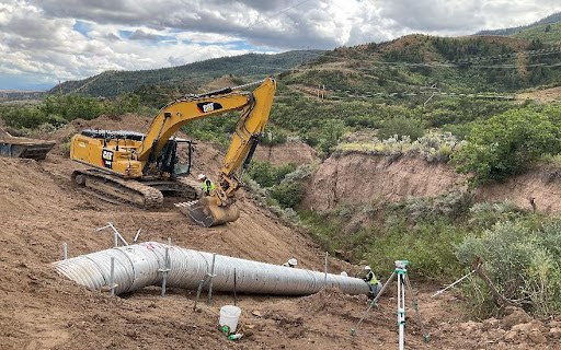 Crews installing a corrugated metal pipe near CO 13 Rio Blanco Hill 
