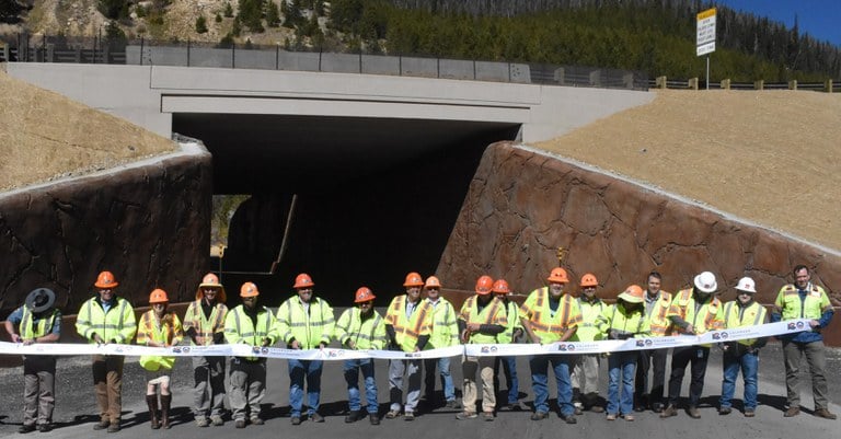 Representatives from contractor partners, partner agencies and CDOT gather to celebrate the resurfacing project and newly rebuilt emergency access structure (shown in background).