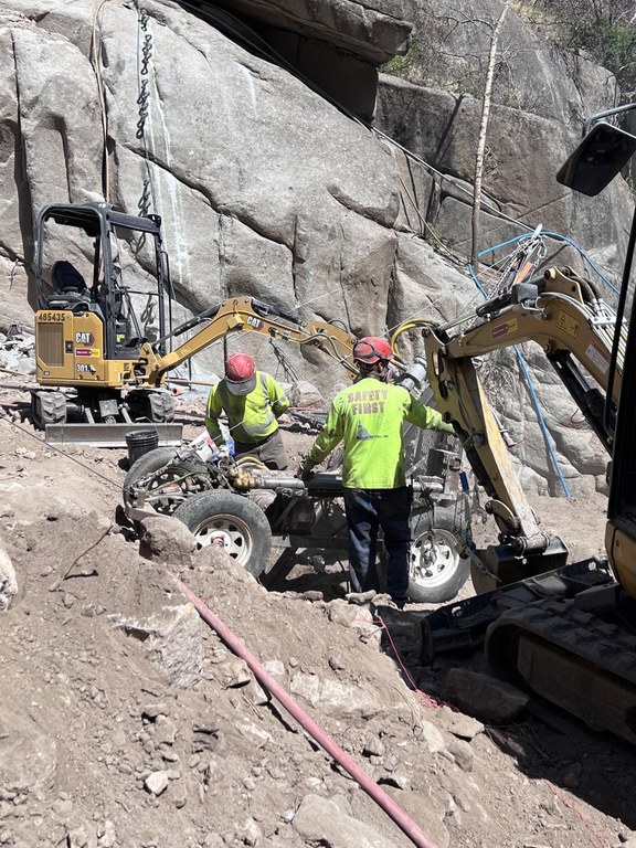 Crews preparing equipment to haul up the side of a rockface