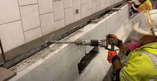Crews using a jack hammer for wall repairs in the Eisenhower Johnson Memorial Tunnel