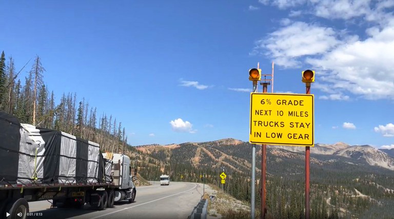 A semi-truck descends the east side of Monarch Pass on US Hwy 50 between Gunnison and Poncha Springs where posted signs warn drivers of the 6% steep grade for 10 miles. 