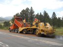 Tandem axle dump trucks (left) and chip spreaders (right) combine together for a chipsealing operation. CDOT applies washed stones to the top of an asphalt roadway to seal cracks and add friction to the roadway for safety. These are usually seen in rural areas of the state or areas with low traffic counts. thumbnail image
